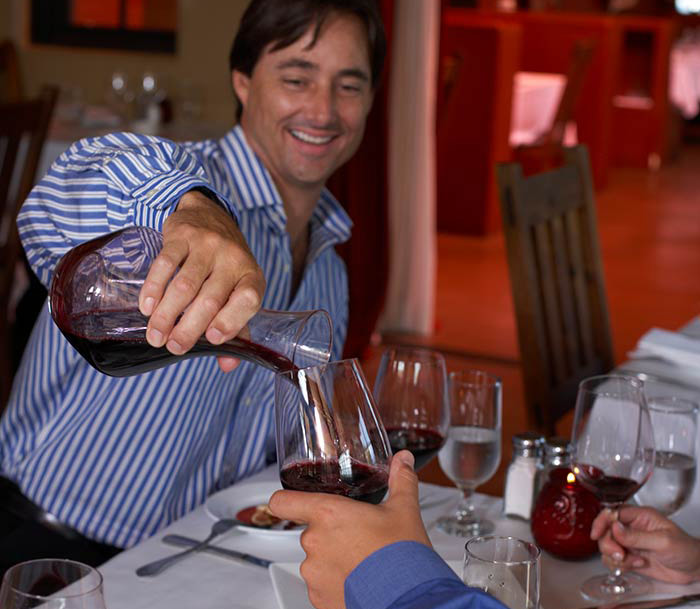 man pouring glass of red wine